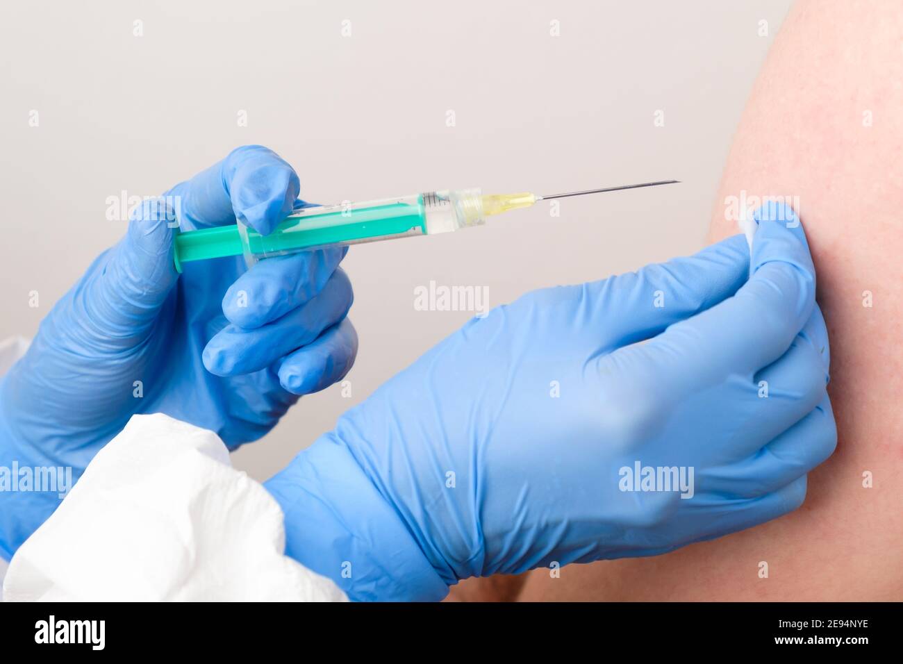 Un medico o un infermiere in guanti di gomma dà un colpo o un'iniezione. Vaccinazione contro il coronavirus, SARS-Cov-2. Foto Stock