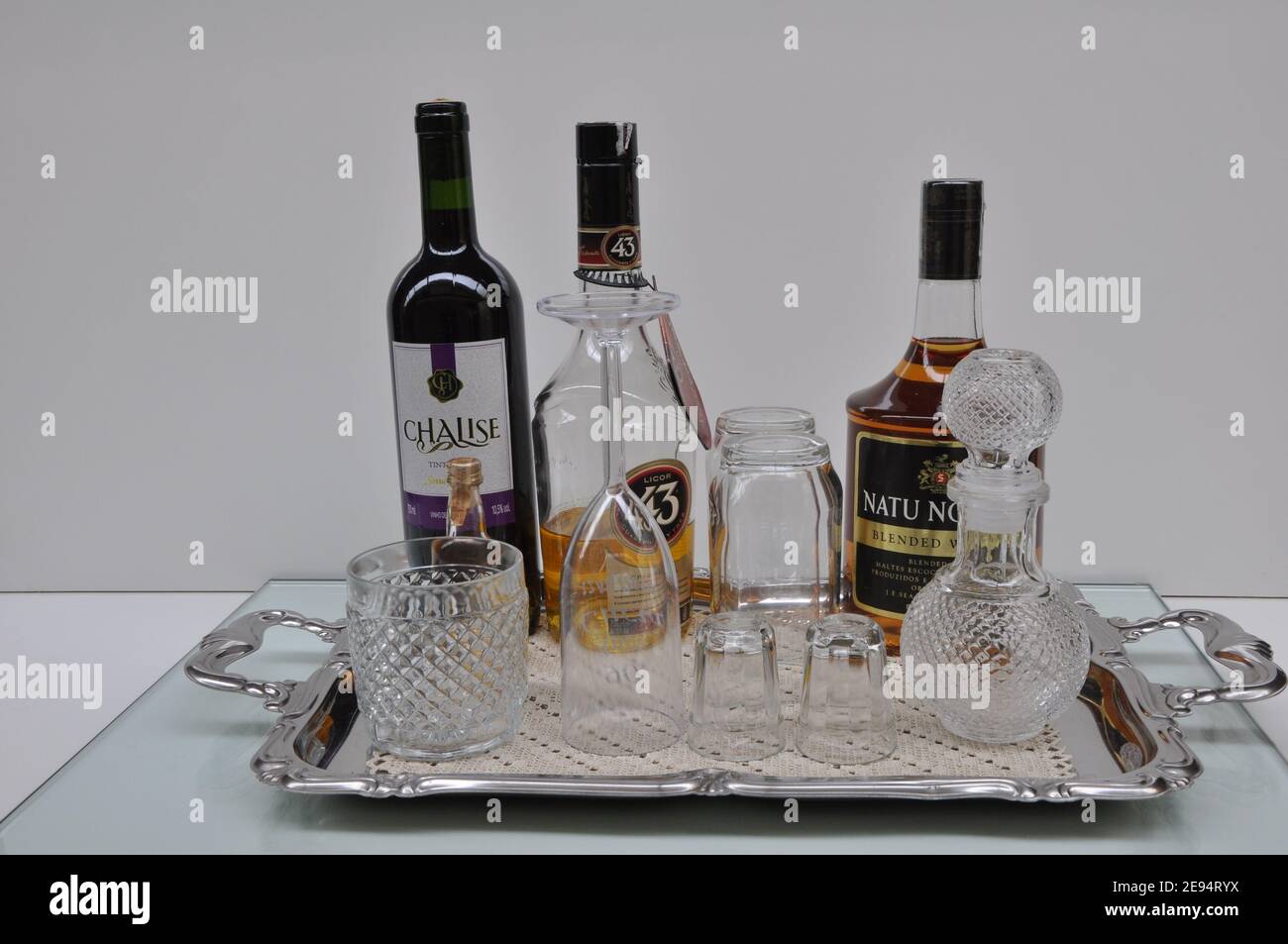 Vassoio in alluminio su base in vetro con bottiglia di vino, liquore, whisky, vetro di cristallo e contenitore in vetro, fondo bianco, Brasile, Sud America Foto Stock