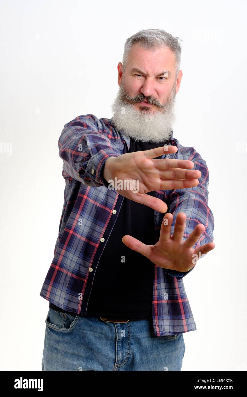 Studio ritratto di uomo maturo bearded in abiti casual mostra il segno di arresto mano, gesto non più, sfondo bianco, spazio copia Foto Stock