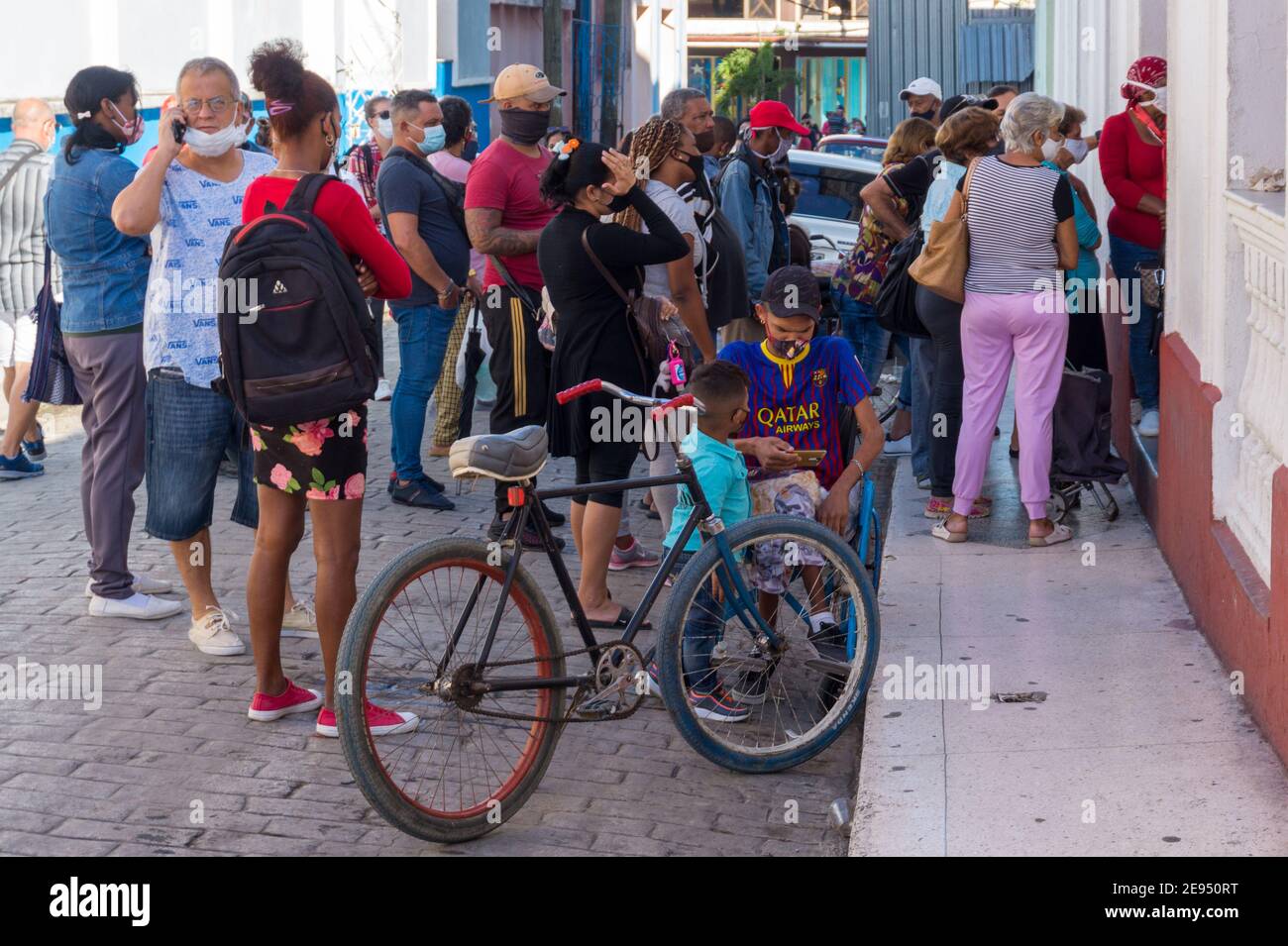 La gente cubana si sta schierando per comprare il pane a El rapido, che si trova nel centro della città. È il tempo del Covid-19 a Santa Clara, Cuba Foto Stock