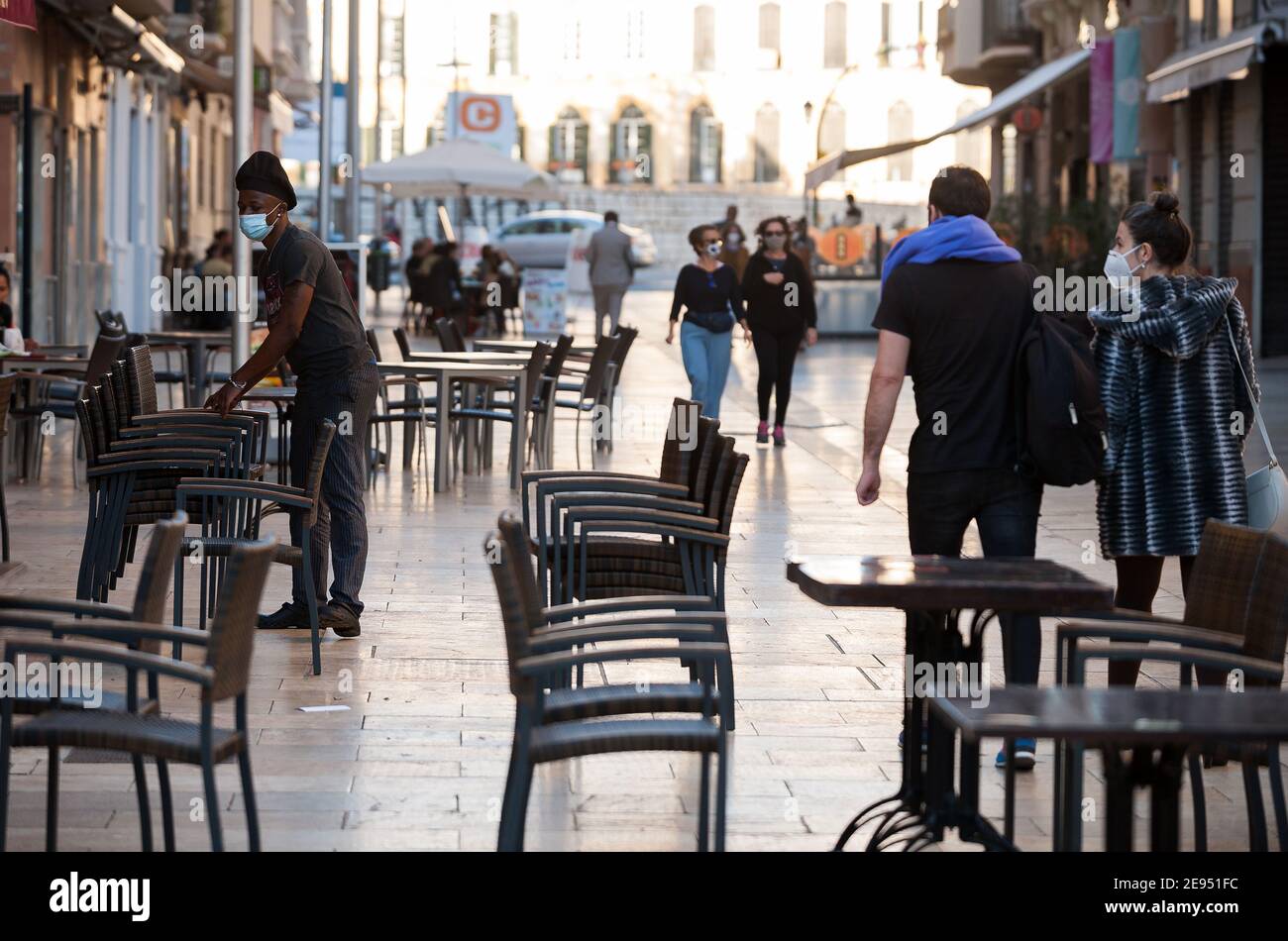 Un lavoratore accatastato sedie al di fuori della terrazza vuota del ristorante la plaza Malaga durante la chiusura del settore dell'ospitalità e attività non essenziali come parte di una chiusura parziale. Per due settimane, oltre al limite di mobilità tra città, molti comuni e distretti della Costa del Sol (compresa la capitale di Malaga) dovrà chiudere bar, ristoranti e negozi come misure per frenare la diffusione della pandemia di coronavirus. In Andalusia, Malaga è la città con più infezioni da coronavirus quotidiano e un alto tasso di ricoveri. Foto Stock