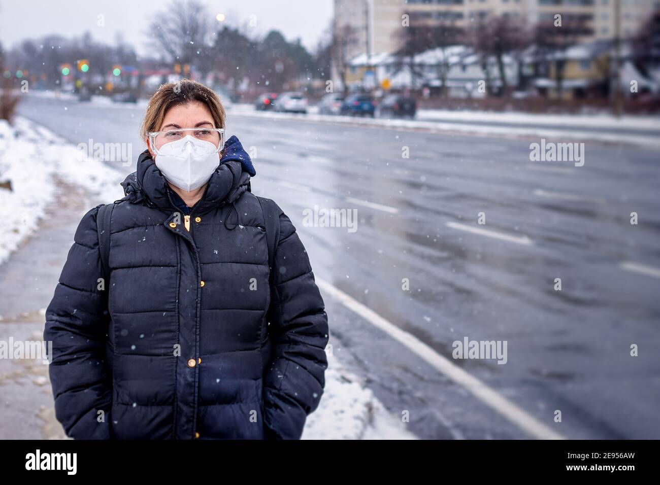 Covid-19 o Coronavirus, una donna che indossa una maschera protettiva in inverno, Canada, 2021 Foto Stock