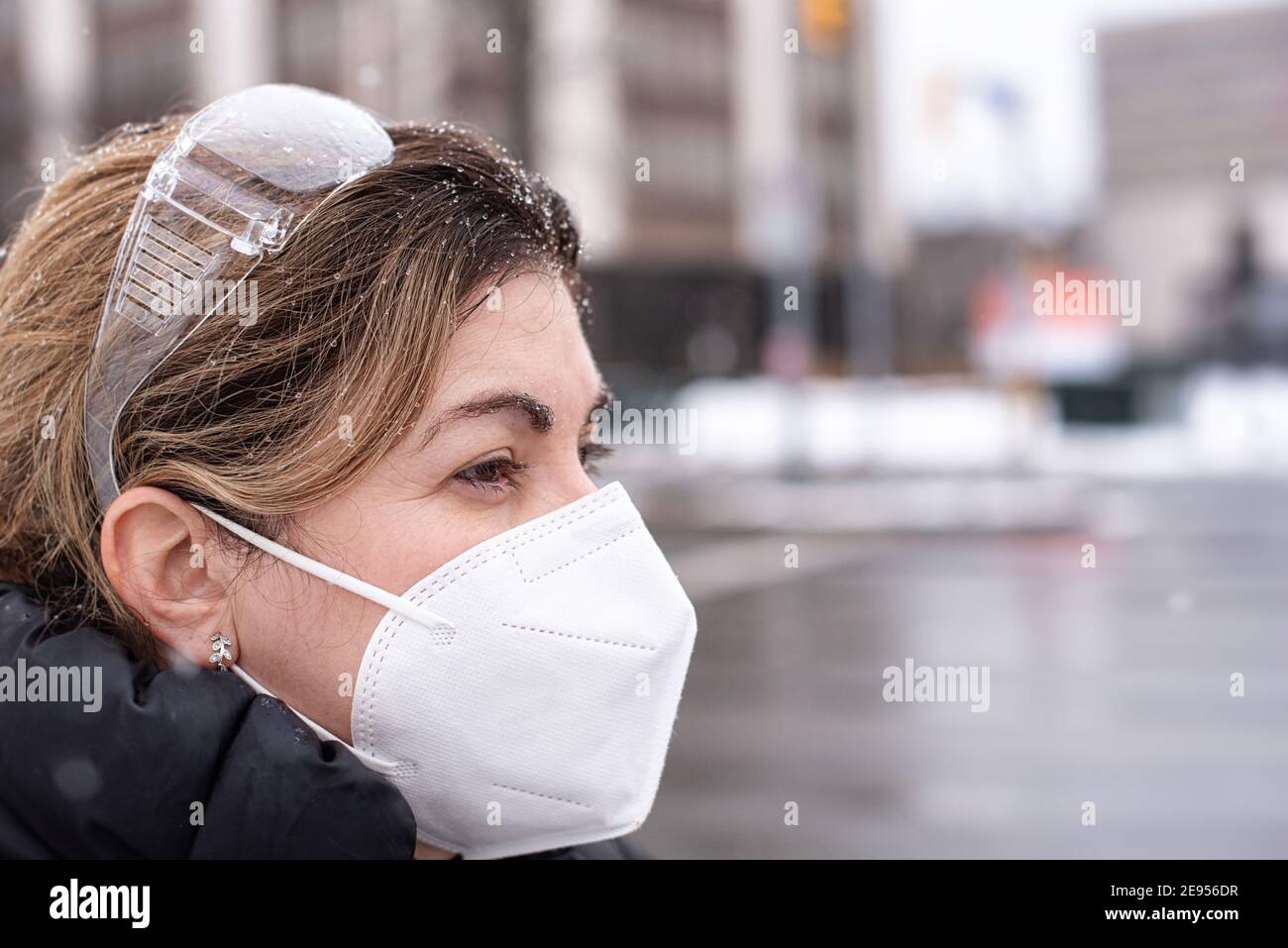 Covid-19 o Coronavirus, una donna che indossa una maschera protettiva in inverno, Canada, 2021 Foto Stock