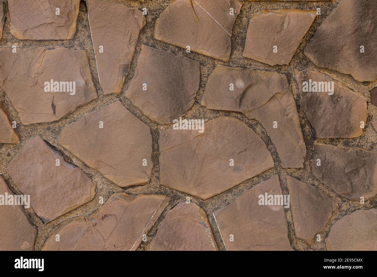 muro fatto di pietre e calcestruzzo come sfondo e carta da parati Foto Stock