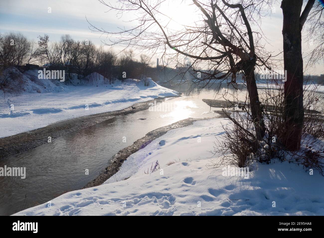 Paesaggio invernale con fiume, albero e sole 2021 Foto Stock