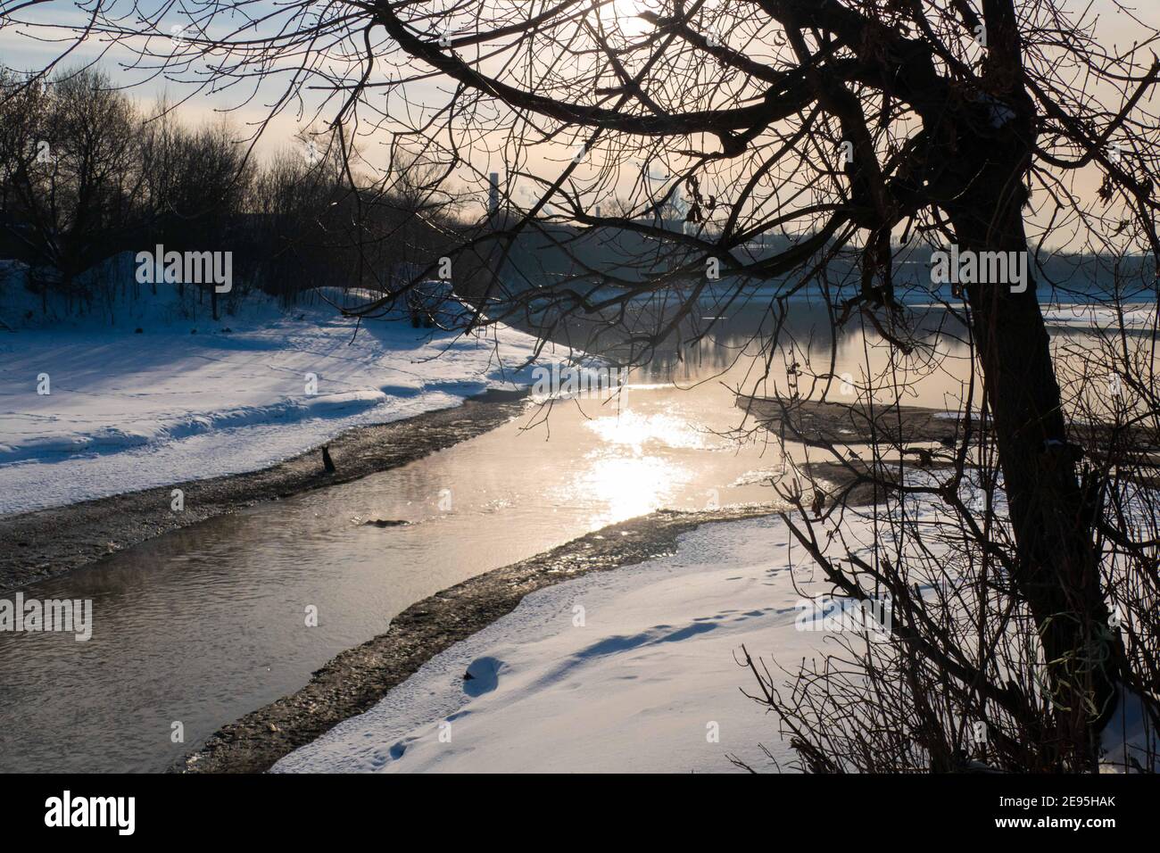 Paesaggio invernale con fiume, albero e sole 2021 Foto Stock