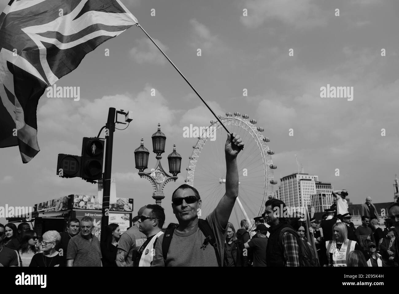 LONDRA - MARZO 2019: Un uomo fa ondere una bandiera di Union Jack sul ponte di Westminster durante un raduno per la Brexit. Foto Stock