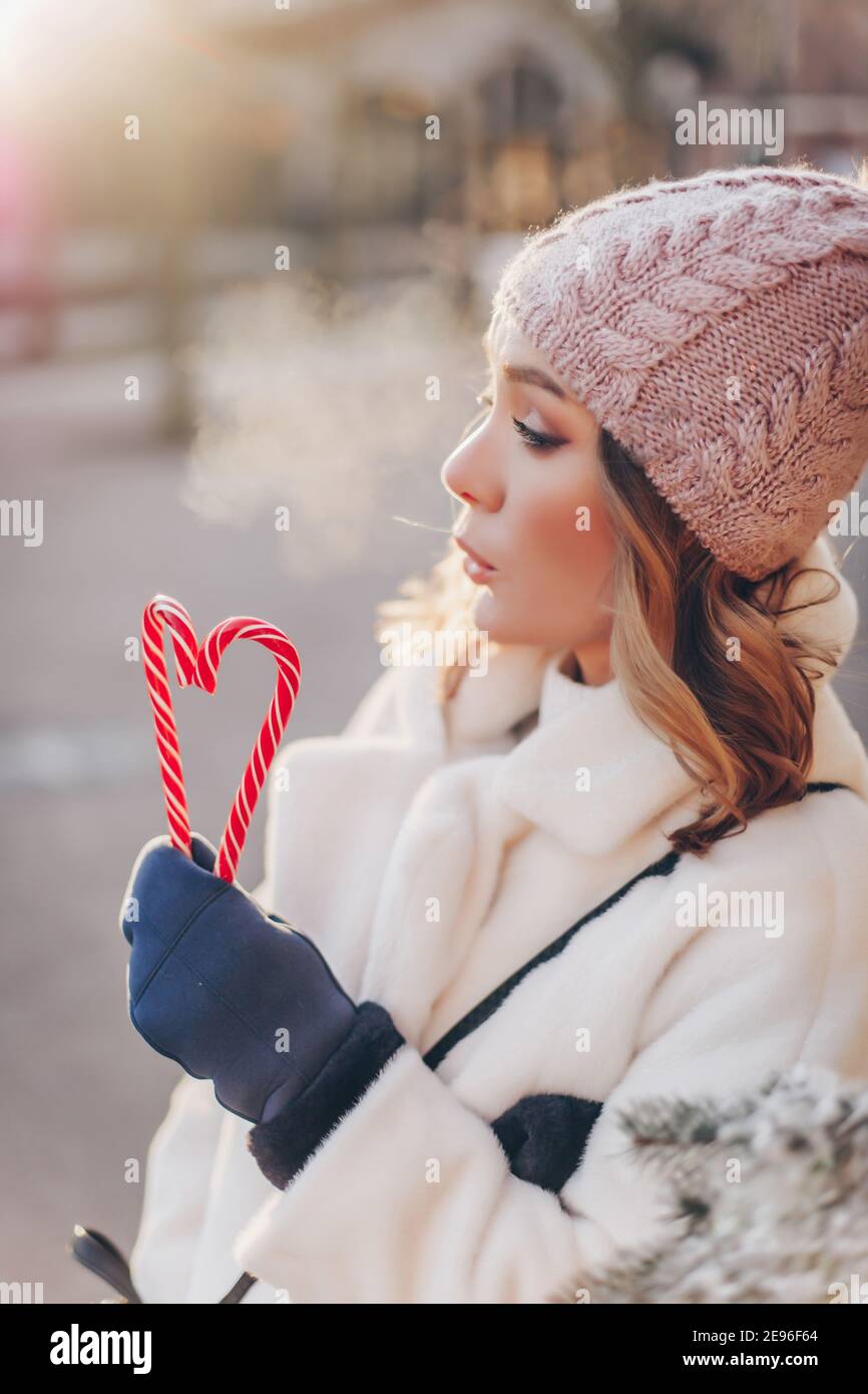 ragazza che cammina nel parco con una caramella a strisce dentro la forma di un cuore Foto Stock