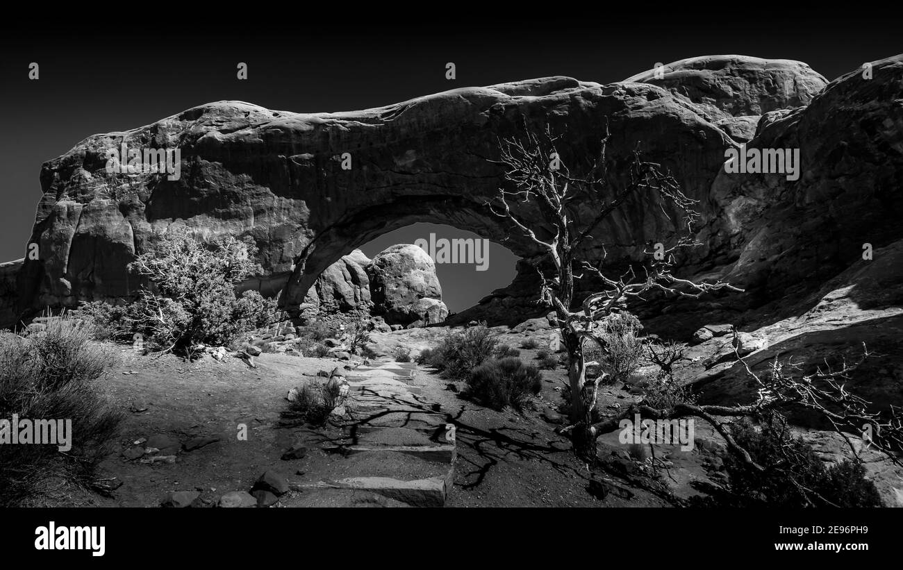 Foto in bianco e nero del North Window Arch, uno dei molti grandi archi di arenaria nel Parco Nazionale di Arches, Utah, Stati Uniti Foto Stock