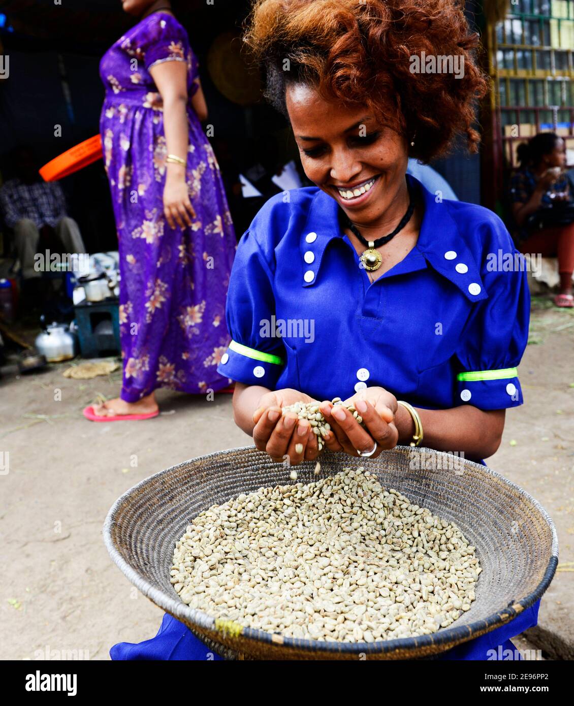 Una donna Tigray smistare i rifiuti dal mucchio di chicchi di caffè fresco ad Axum, Etiopia. Foto Stock