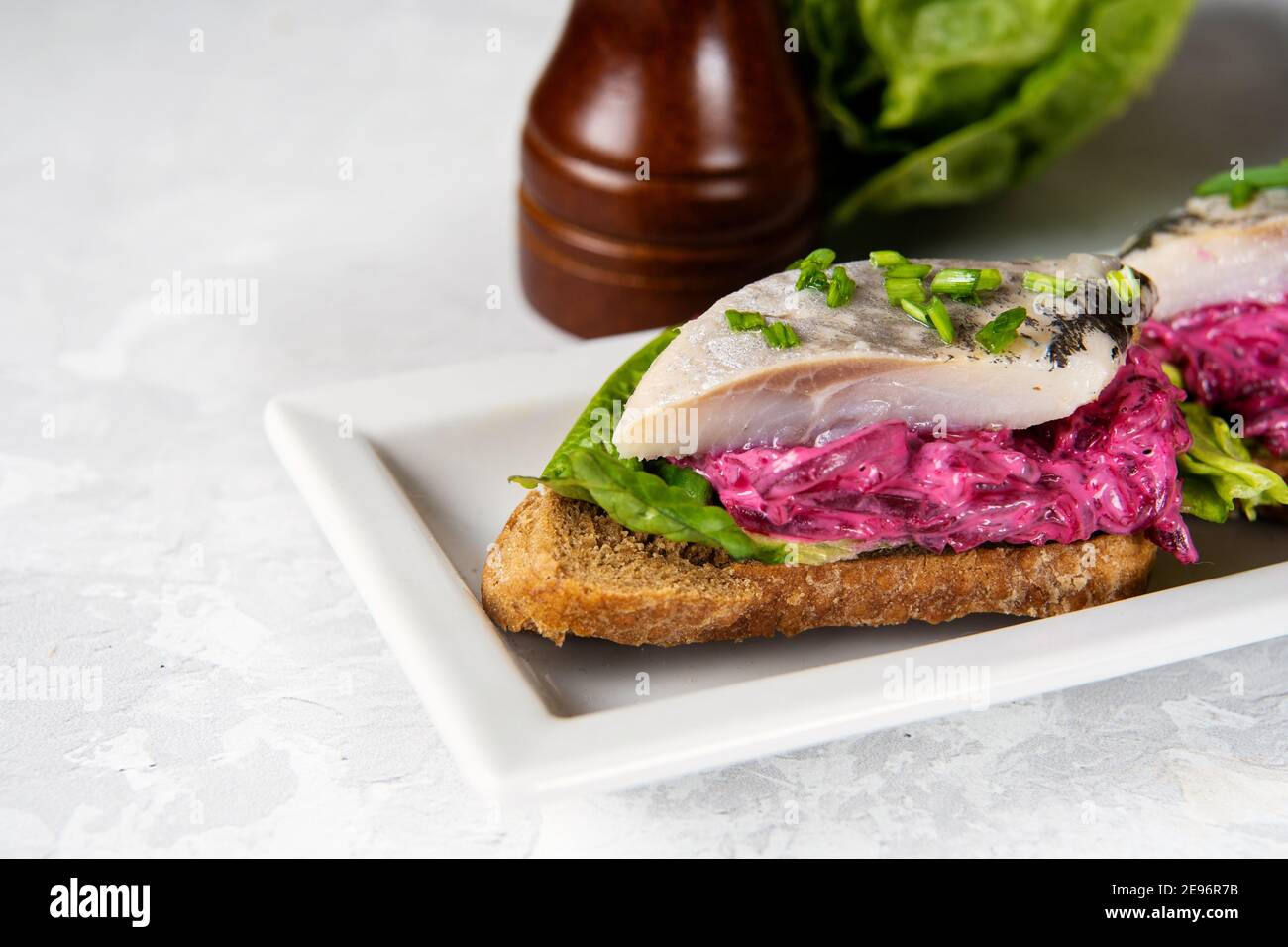 Primo piano di sandwich di aringhe con barbabietola e insalata verde Foto Stock