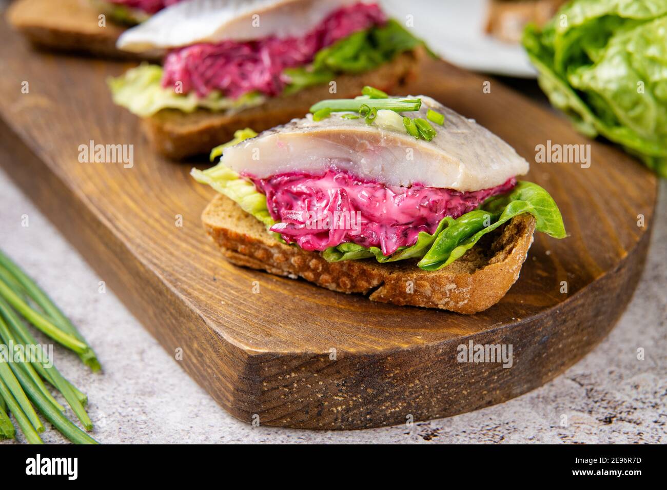 Primo piano di sandwich di aringhe con barbabietola e insalata verde Foto Stock