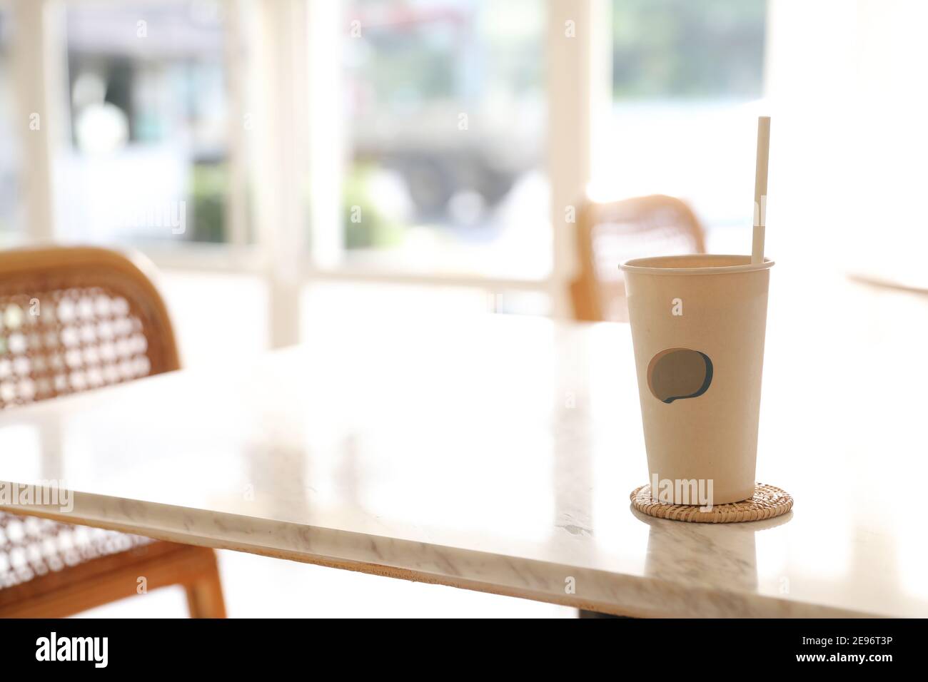 Caffè ghiacciato con vetro di carta sullo sfondo della caffetteria Foto Stock