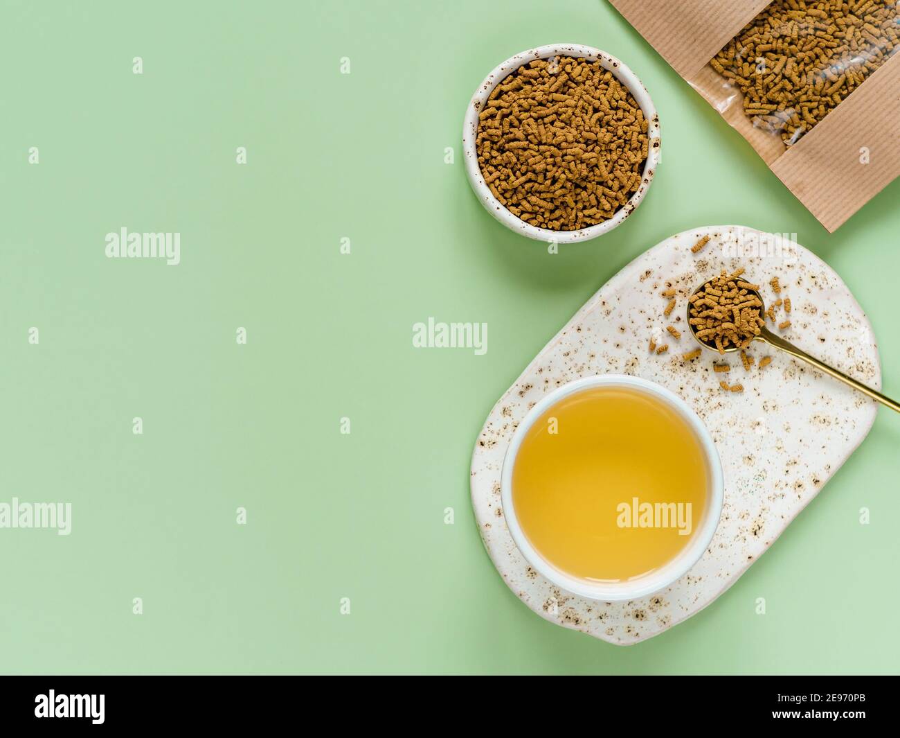 Tazza di tè di grano saraceno su sfondo verde chiaro. Vista dall'alto del tè sano di soba e dei semi di grano saraceno tartarico su sfondo verde. Disposizione piatta. Spazio di copia Foto Stock