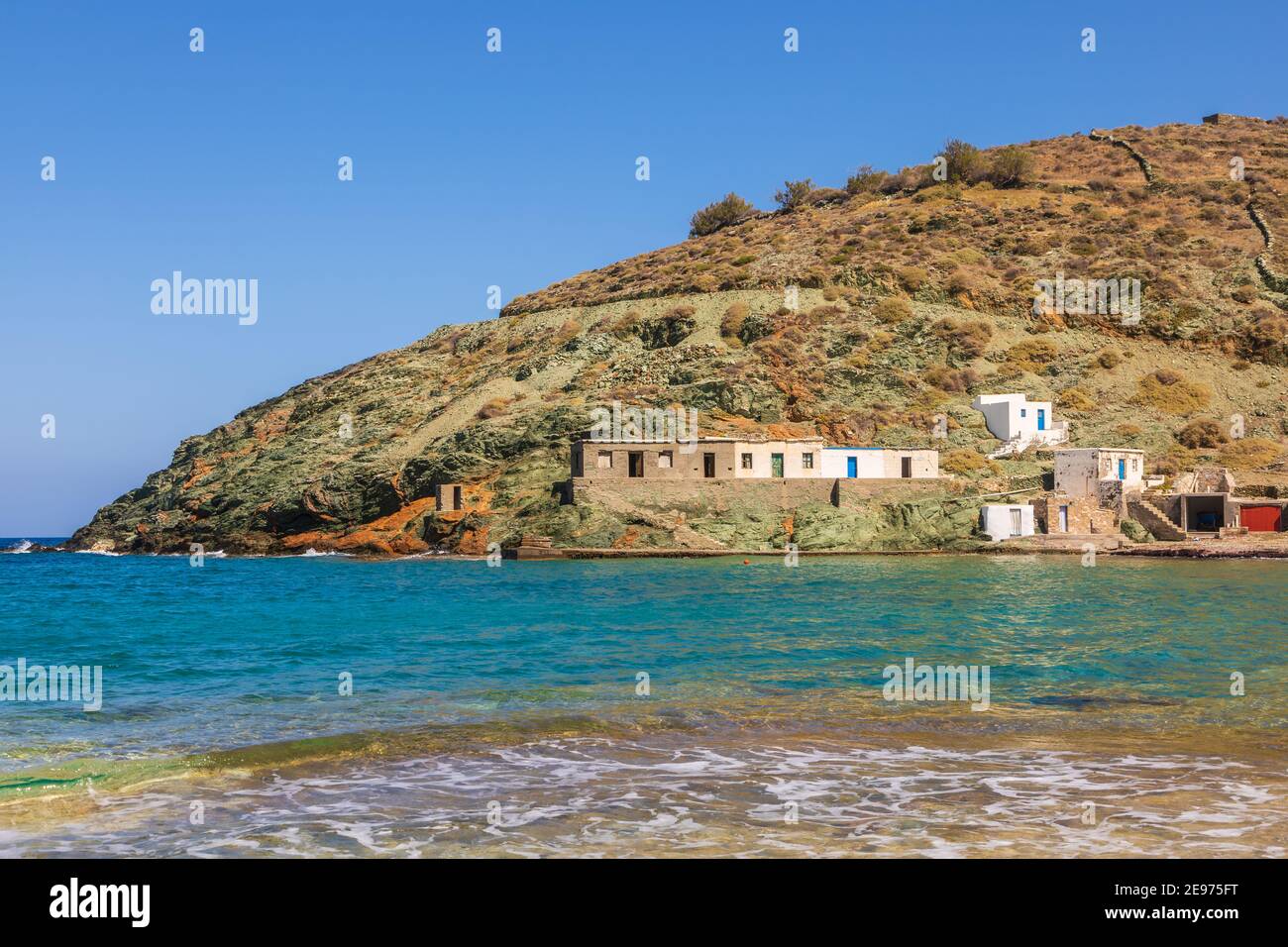 Vista sulla costa e sulla spiaggia di Agios Georgios dell'isola di Folegandros. Piccoli edifici sul pendio. Mar Egeo, Arcipelago delle Cicladi, Grecia. Foto Stock