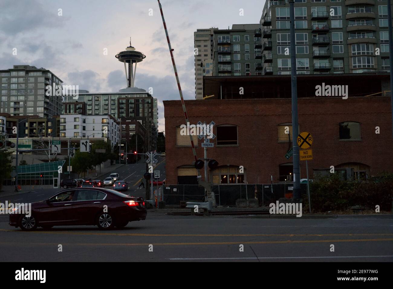 Seattle, WA-11.28.2018: Lo Space Needle di Seattle si innalza dietro i numerosi appartamenti. A destra, un'auto si muove dietro la vecchia fabbrica di Spaghetti. Foto Stock