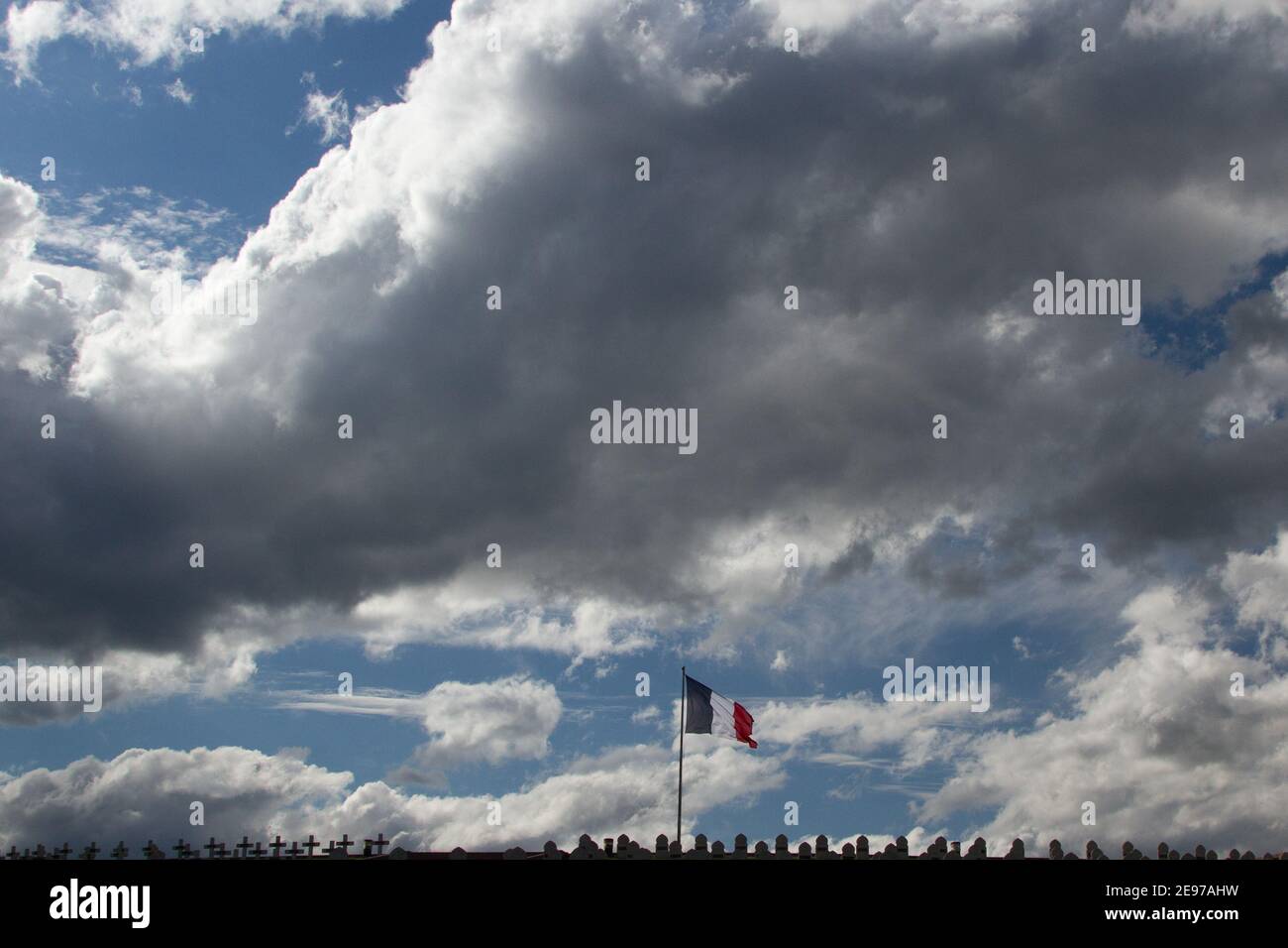 Bandiera francese che fronteggia un cielo nuvoloso Foto Stock