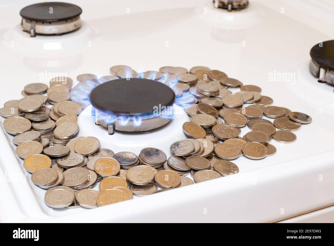 Denaro e bruciatore a gas su sfondo bianco con spazio per il testo. Il costo del gas naturale nel mondo Foto Stock