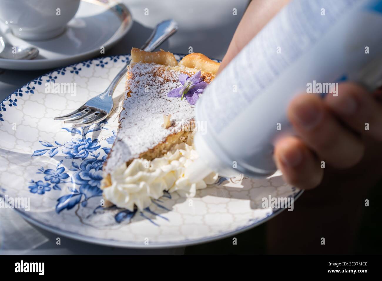 Aggiungere la crema alla torta di pasqua appena fatta. Torta con decorazione di fiori e crema all'aperto. Foto Stock