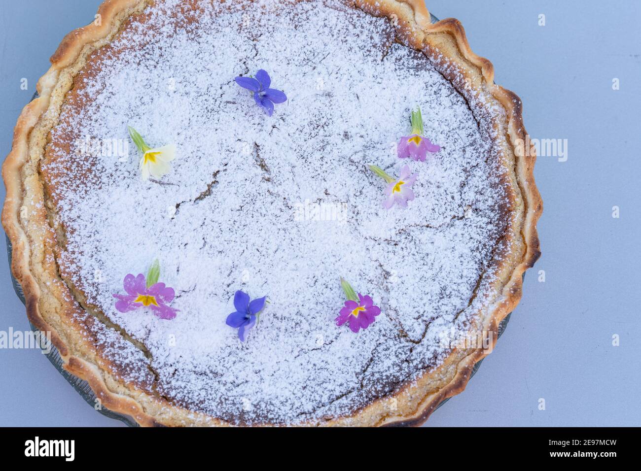 Torta di pasqua fresca e fatta in casa con decorazione floreale su sfondo grigio. Foto Stock