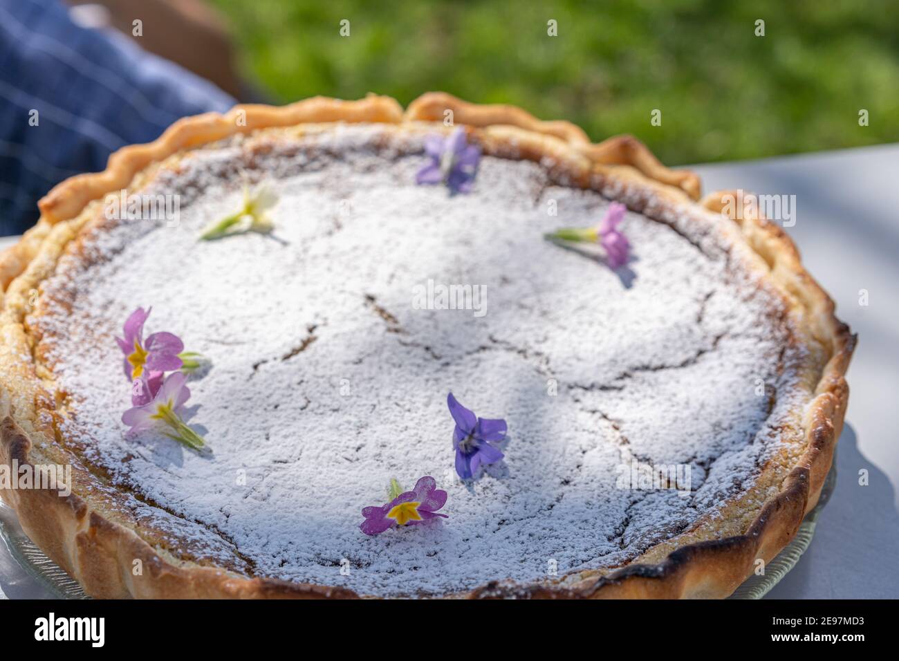 Torta di pasqua fresca fatta in casa su tavola con decorazione floreale in giardino. Foto Stock