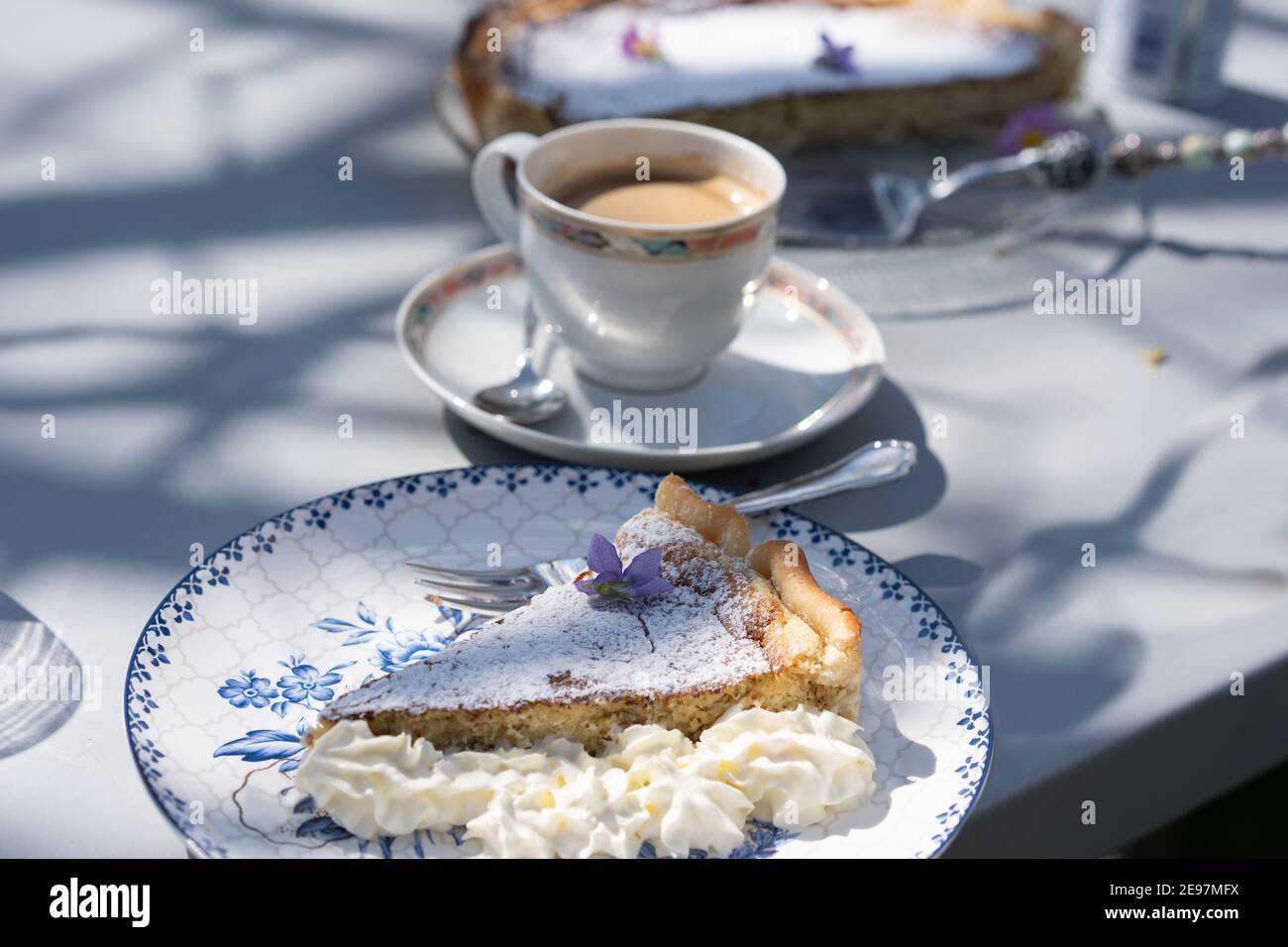 Torta di pasqua fresca fatta in casa con decorazione floreale e caffè all'aperto. Foto Stock