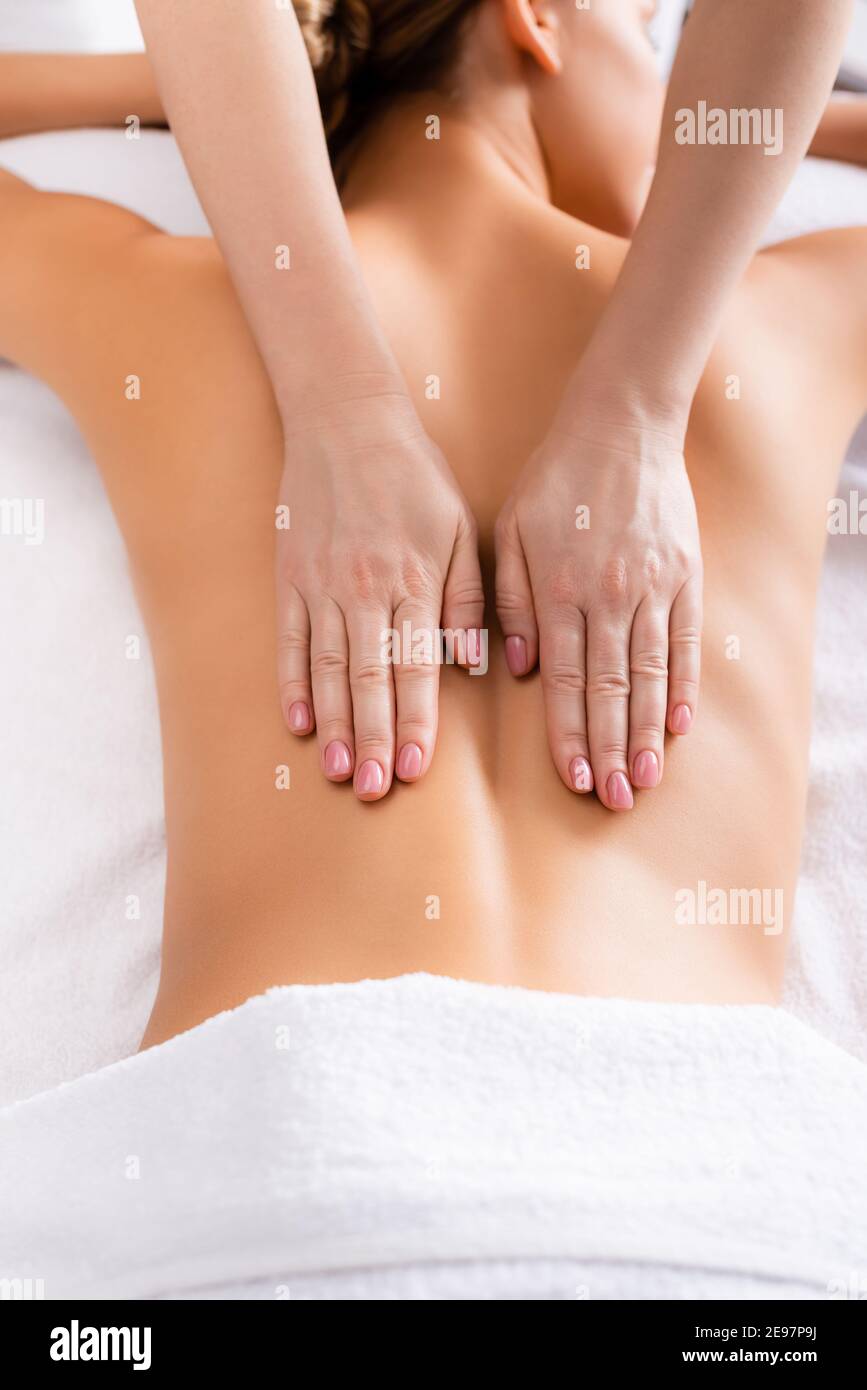 vista ritagliata del massaggiatore che si trova sul tavolo da massaggio Foto Stock