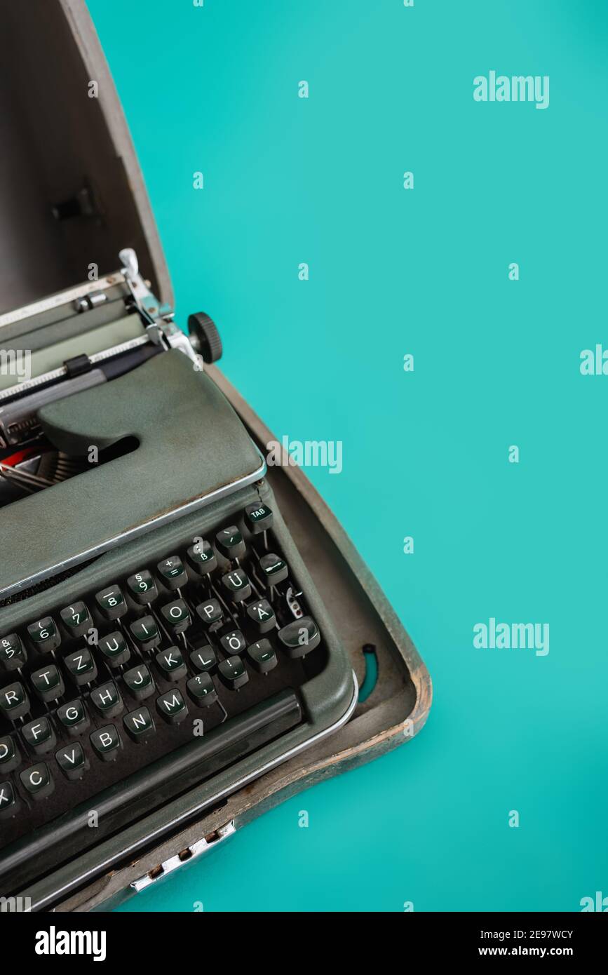 macchina da scrivere retrò in cassa aperta su sfondo turchese Foto Stock