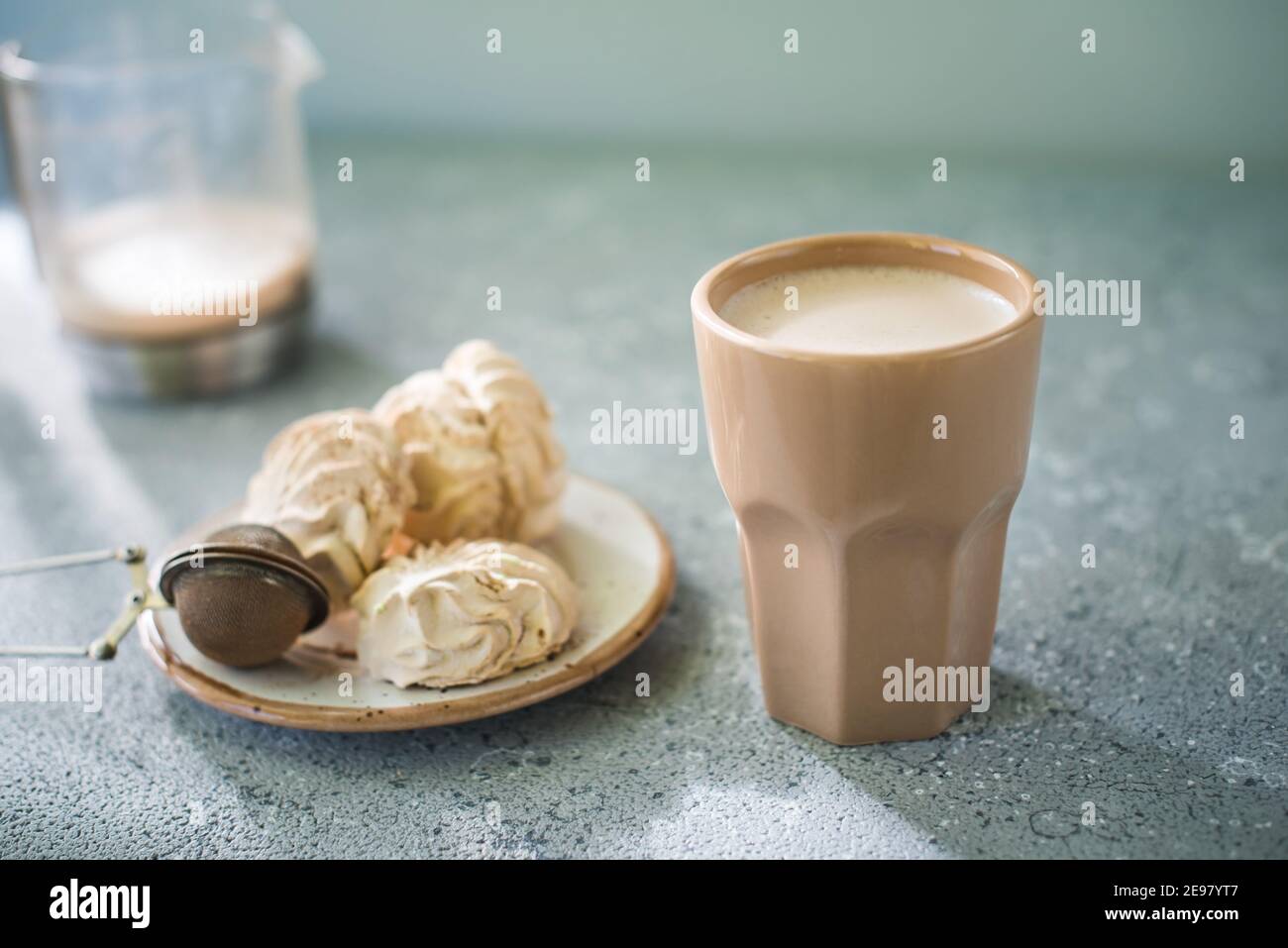 Una bevanda in un bicchiere di ceramica e una torta sul tavolo. La colazione era buona. Foto Stock