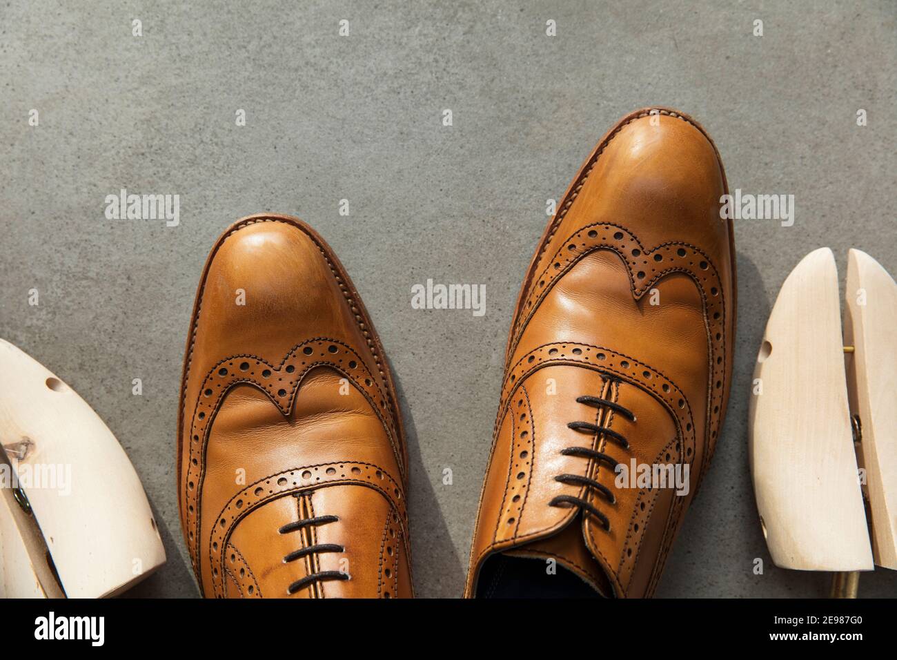 Vista dall'alto di un paio di uomini in pelle marrone chiaro scarpe formali  su cemento Foto stock - Alamy