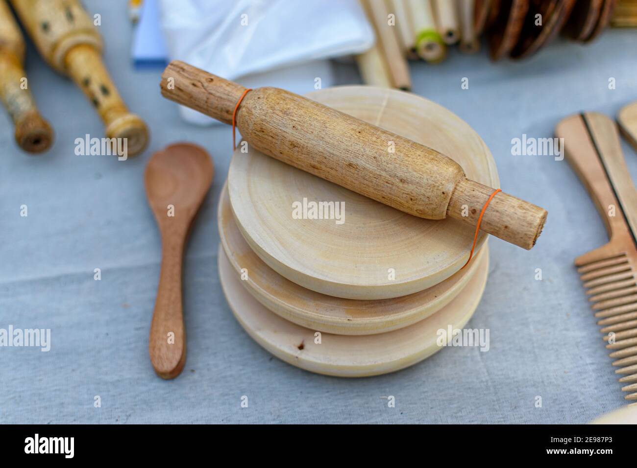 Immagine di un produttore di roti in legno fatto a mano è esposto in un negozio per la vendita su sfondo sfocato. Artigianato indiano.(fuoco selettivo) Foto Stock