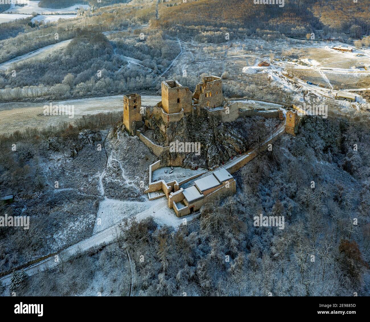 Foto aerea innevata sulle rovine del castello di Csesznek a Bakony Mountain Ungheria. Costruito da Jakab Cseszneki nel 1263. Incredibili rovine di edifici storici. Foto Stock