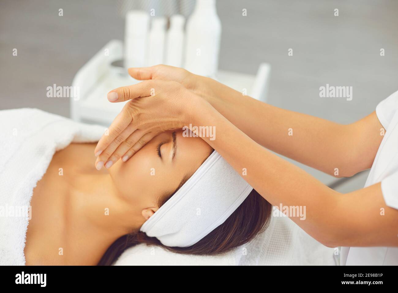 Massaggiatore per la preparazione di un massaggio rilassante manuale professionale per giovani donne faccia Foto Stock