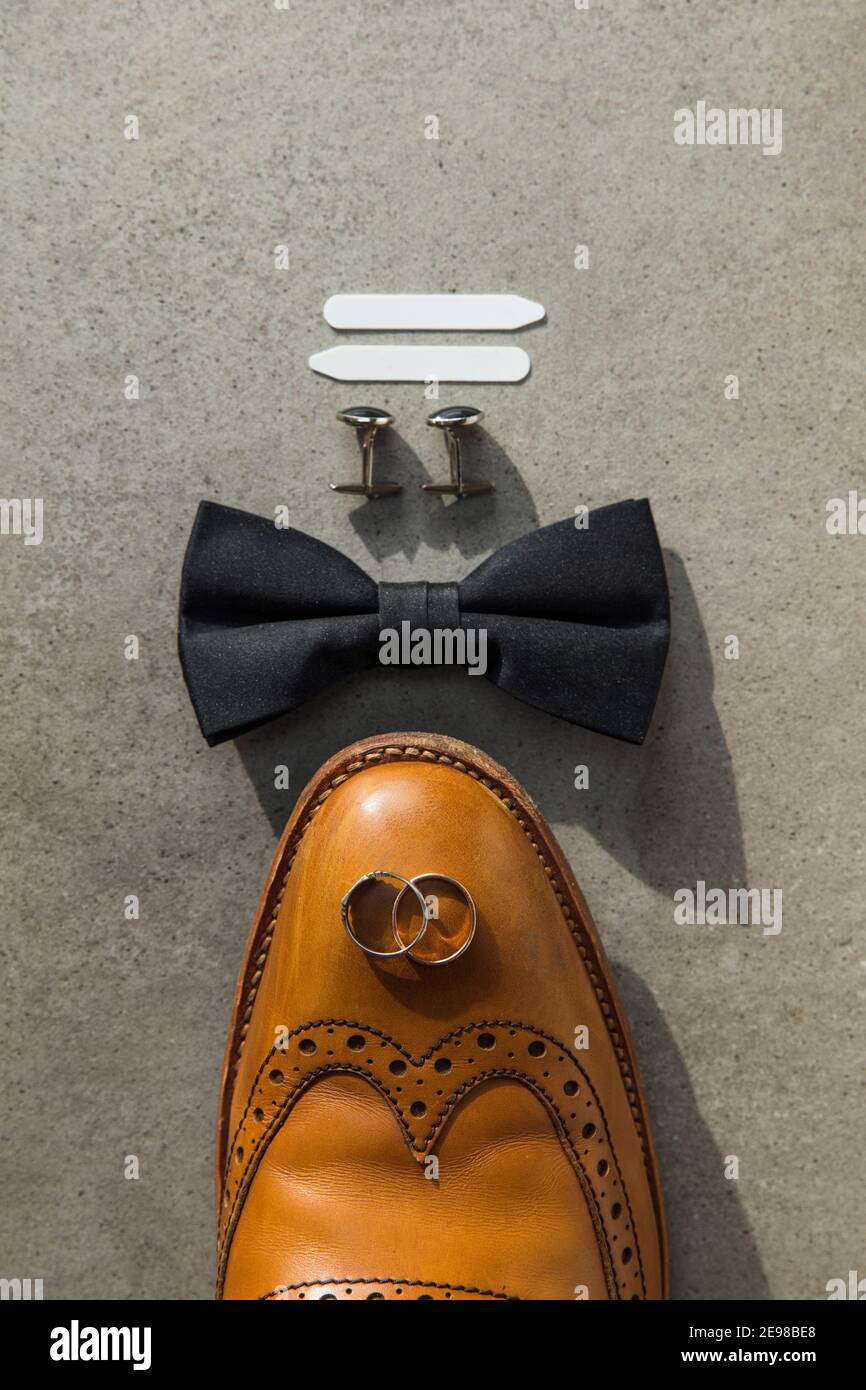 Ponga lo sfondo piatto del giorno di nozze del groomsman con gli anelli e la scarpa Foto Stock