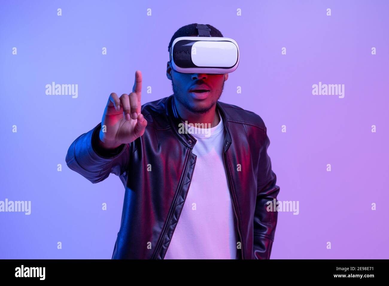 Il Black Guy è entusiasta di occhiali e giacca VR che si divertisce con Virtual Esperienza di realtà Foto Stock