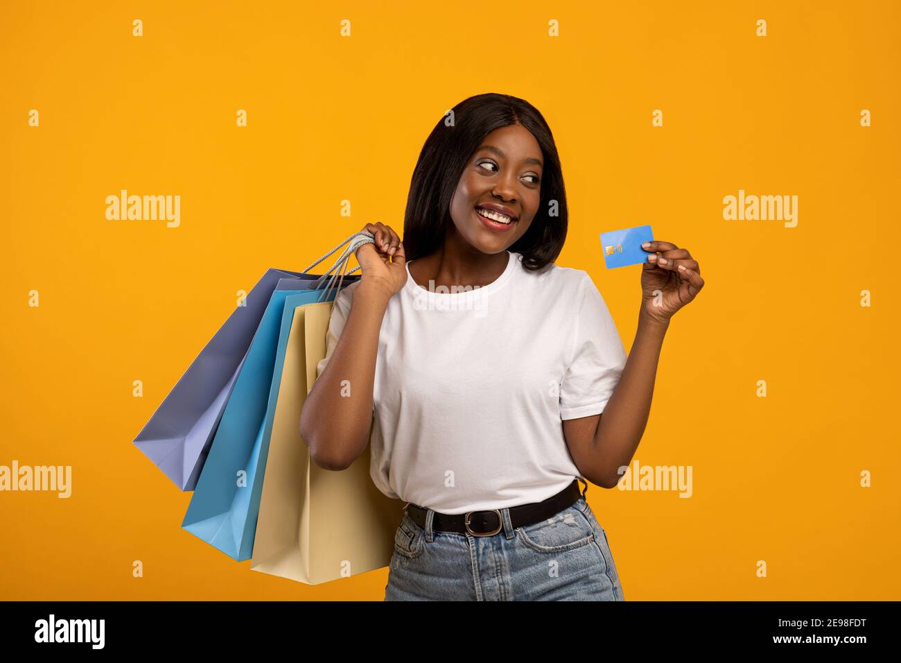 Carino nero donna shopaholic con borse shopping che consiglia carta di credito Foto Stock