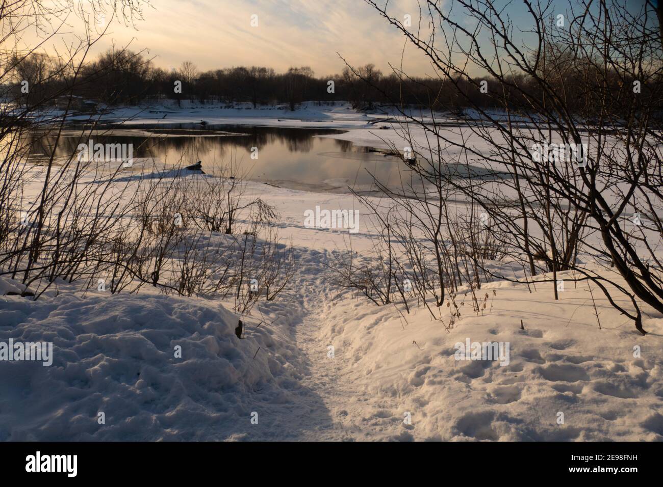 Paesaggio invernale con fiume, albero e sole 2021 Foto Stock