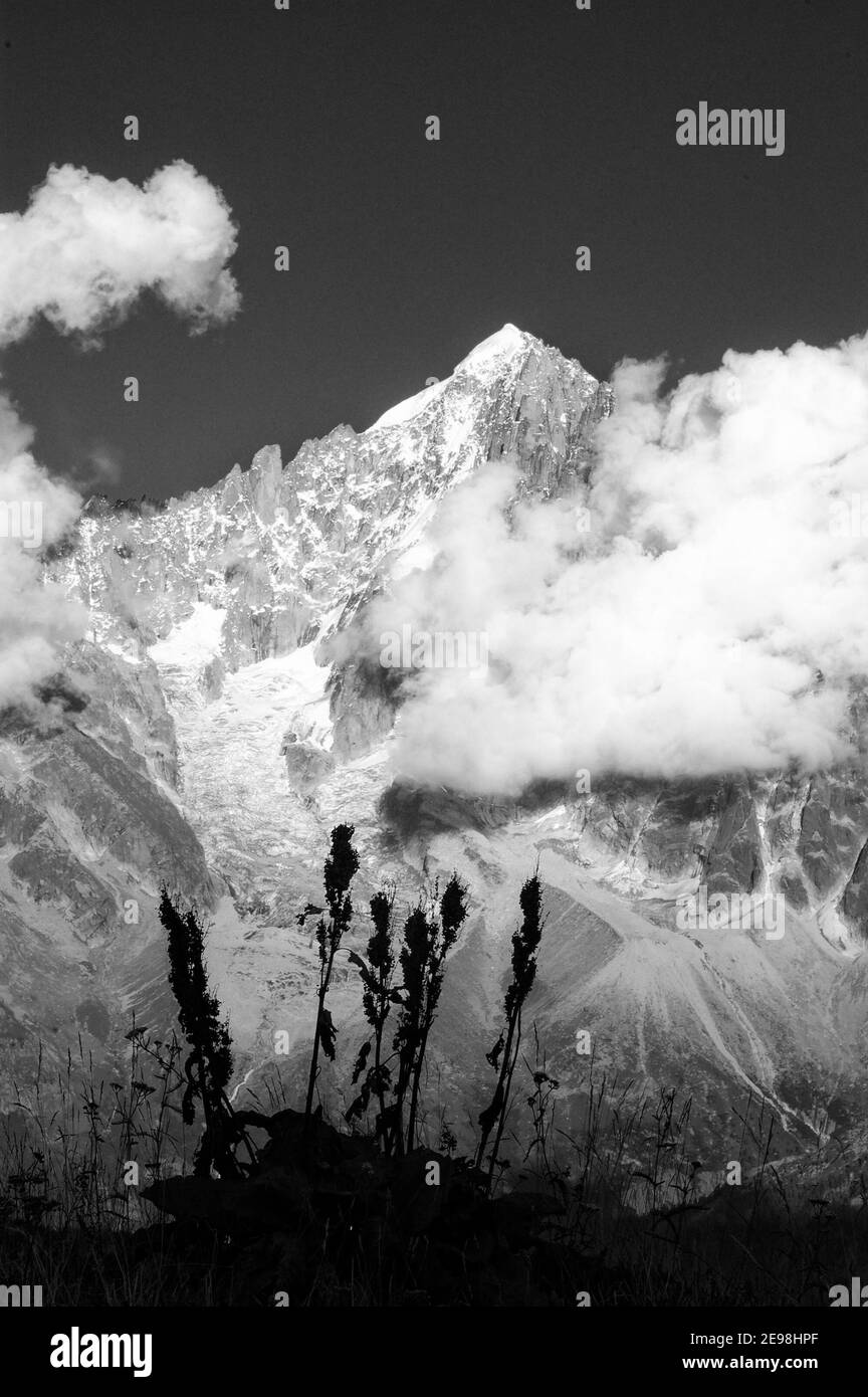 Nuvole nel tardo pomeriggio che si formano intorno alle cime del Chamonix Aiguilles nelle Alpi francesi, Chamonix, Francia Foto Stock