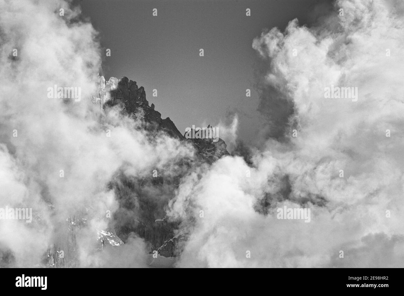 Nuvole nel tardo pomeriggio che si formano intorno alle cime del Chamonix Aiguilles nelle Alpi francesi, Chamonix, Francia Foto Stock