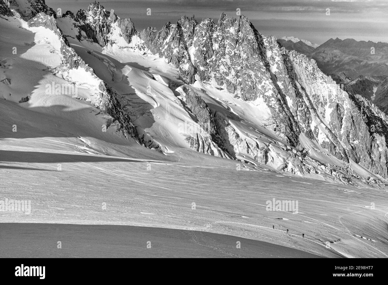Piccole figure di scalatori che attraversano il ghiacciaio le Tour in Le Alpi francesi con l'Aiguille de Chardonnet dietro Foto Stock