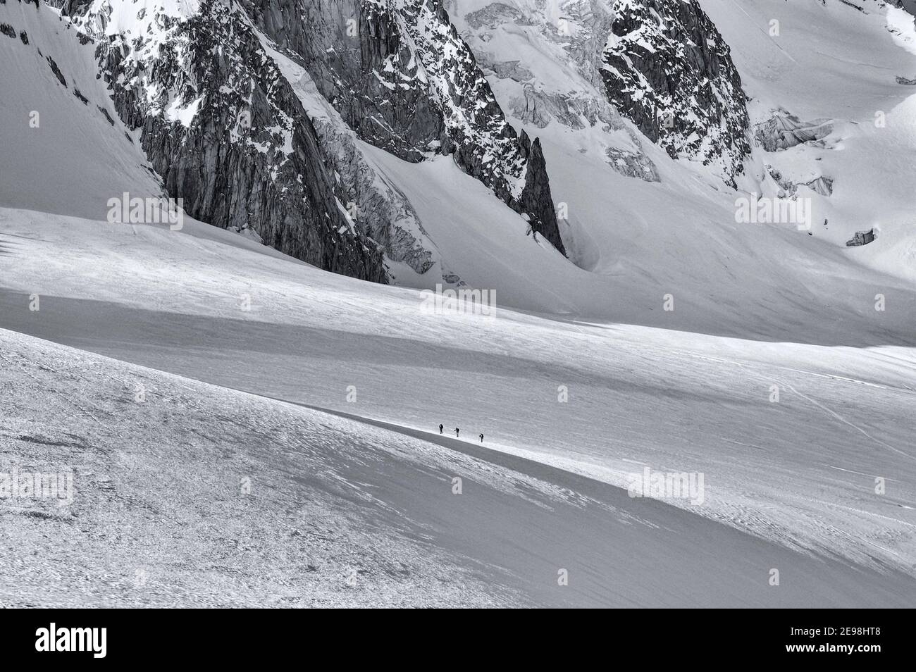 Piccole figure di scalatori che attraversano il ghiacciaio le Tour in Le Alpi francesi con l'Aiguille de Chardonnet dietro Foto Stock