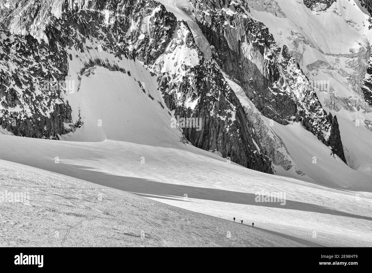 Piccole figure di scalatori che attraversano il ghiacciaio le Tour in Le Alpi francesi con l'Aiguille de Chardonnet dietro Foto Stock