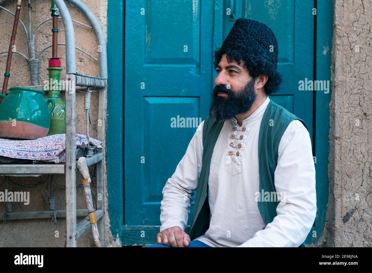 Shiraz, Iran - 04.10.2019: Uomo iraniano con barba epica in cappello  tradizionale, camicia bianca e giubbotto verde. Bell'uomo persiano nel suo  cortile Foto stock - Alamy