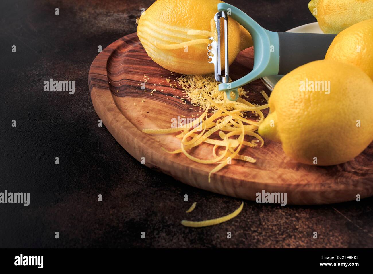 Scorza di limone e grattugia su una tavola di legno su sfondo nero. Messa a  fuoco selettiva Foto stock - Alamy