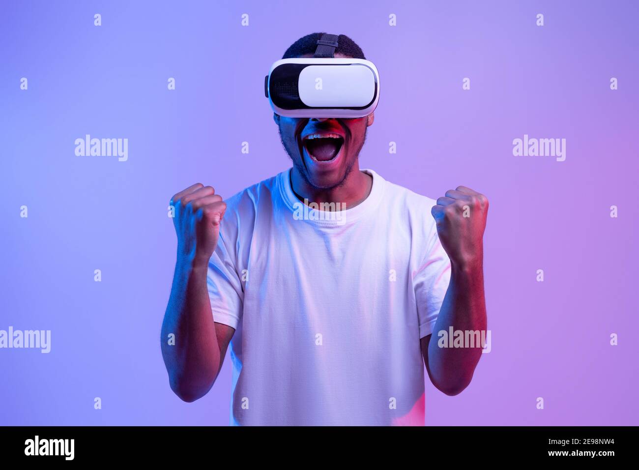 Euforico Black Guy gioco di video gioco in occhiali VR, esclamando con entusiasmo Foto Stock