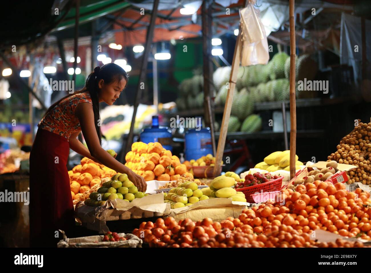 Yangon, Myanmar. 3 Feb 2021. Un fornitore vende frutta ad un mercato notturno in Yangon, Myanmar, 3 febbraio 2021. Il Presidente del Myanmar U Win Myint e il Consigliere di Stato Aung San Suu Kyi saranno detenuti fino al 15 febbraio, un funzionario della Lega Nazionale per la democrazia (NLD) confermato mercoledì. Credit: Xinhua/Xinhua Live News Foto Stock