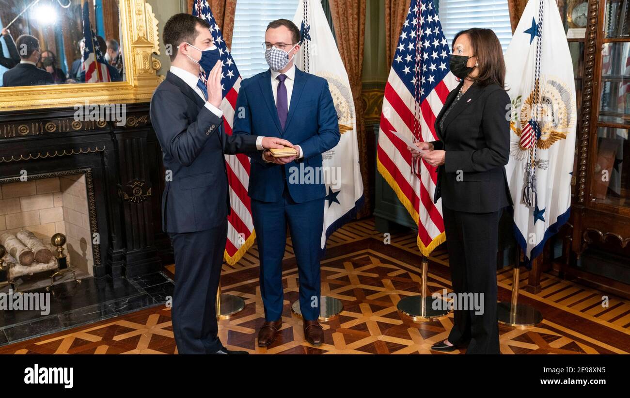 Il Vice Presidente degli Stati Uniti Kamala Harris, a destra, esegue un giuramento cerimoniale in del Segretario del trasporto Pete Buttigieg, a sinistra, come suo marito Chasten Buttigieg guarda al vecchio edificio dell'ufficio esecutivo nella Casa Bianca 3 febbraio 2021 a Washington, DC. Foto Stock