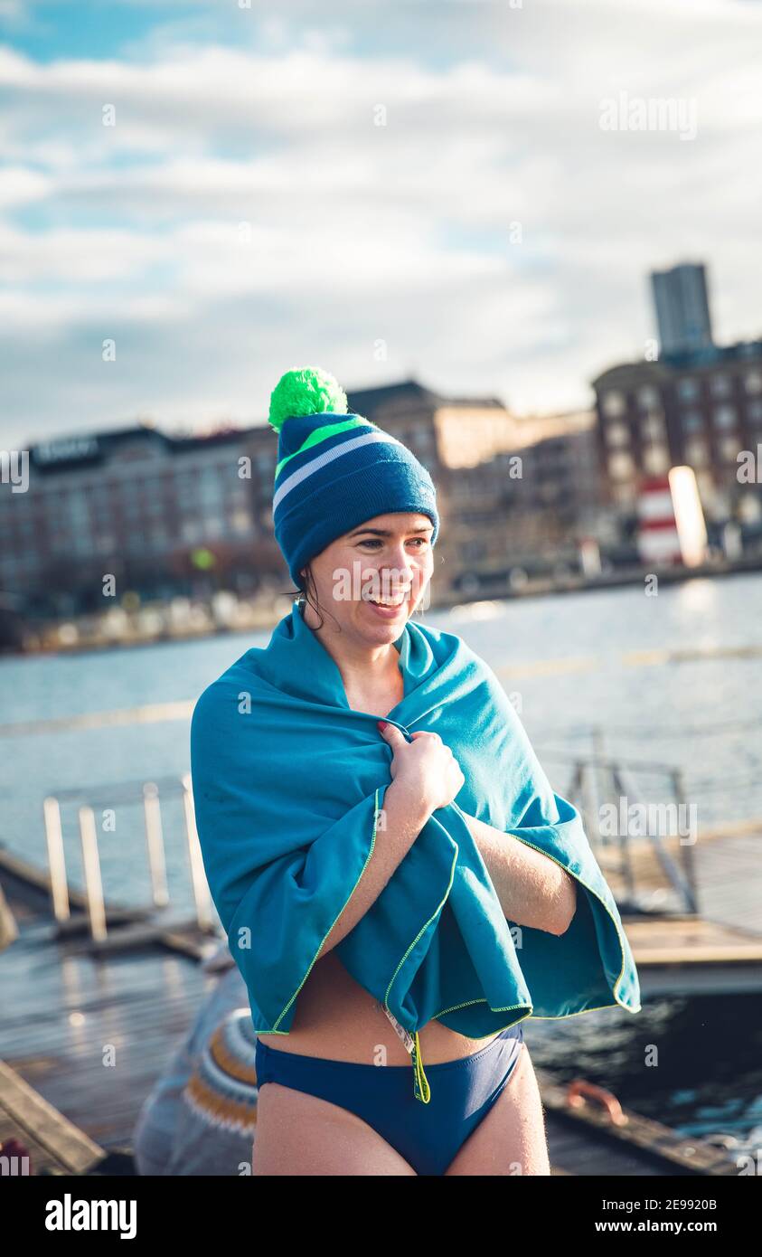 Bagnino invernale avvolto nel Towel che ammolge il sole a Copenhagen Danimarca Foto Stock