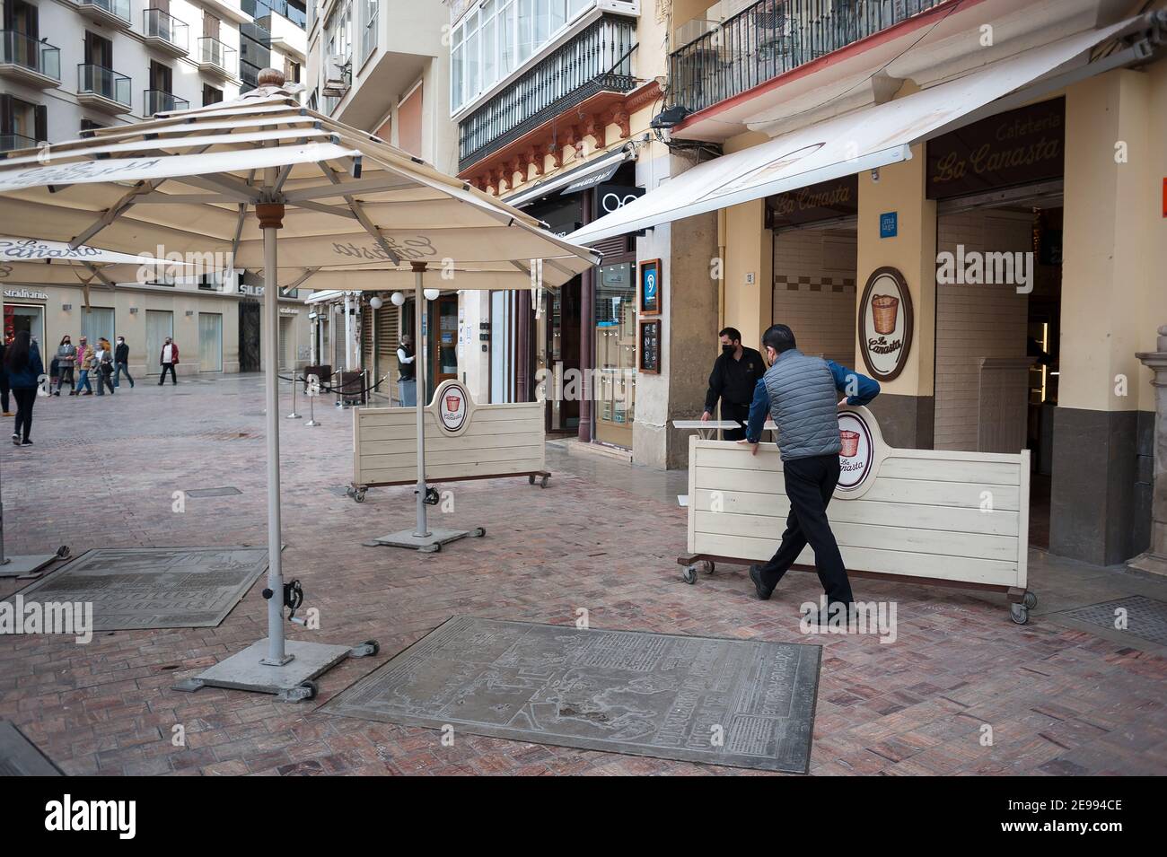 I lavoratori hanno visto le tavole di sollevamento per chiudere una caffetteria in una piazza vuota di Plaza de la Constitución, in mezzo alla chiusura parziale causata dalla pandemia del coronavirus. Foto Stock