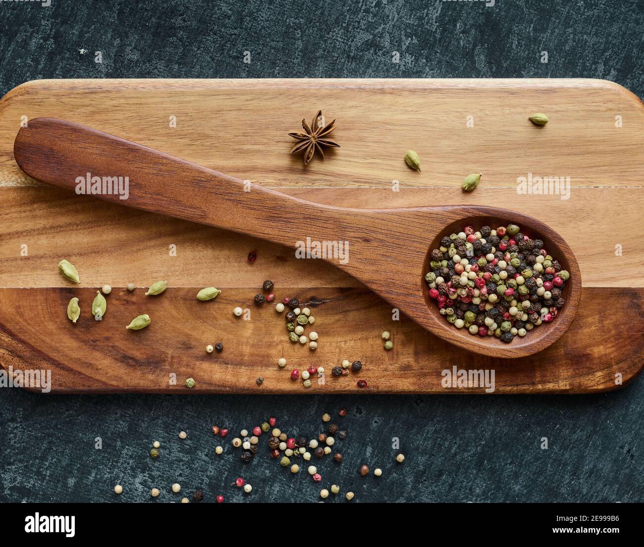 Peppercorn colorate su un cucchiaio di legno, spezie, piatto Foto Stock